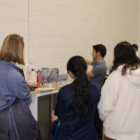 group of people looking at a senior project